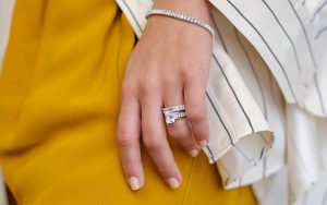 Photo of a woman's hand, showcasing her engagement ring.