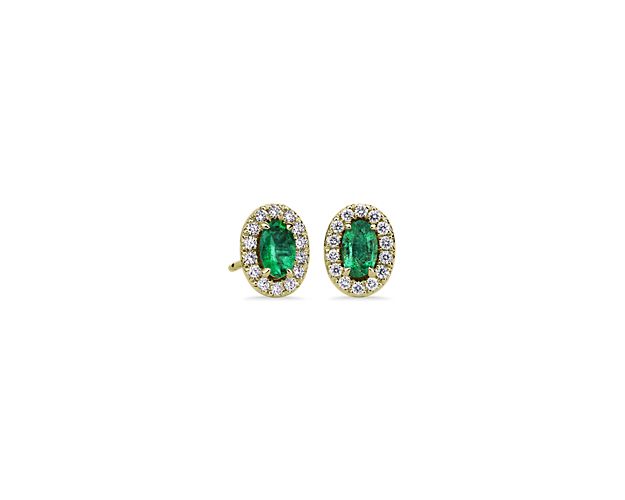 Warm 14k yellow gold makes an oval-cut emerald pop on these stud earrings. Finished with symmetrical diamond halos, these glittering accessories will draw the eye of your company.