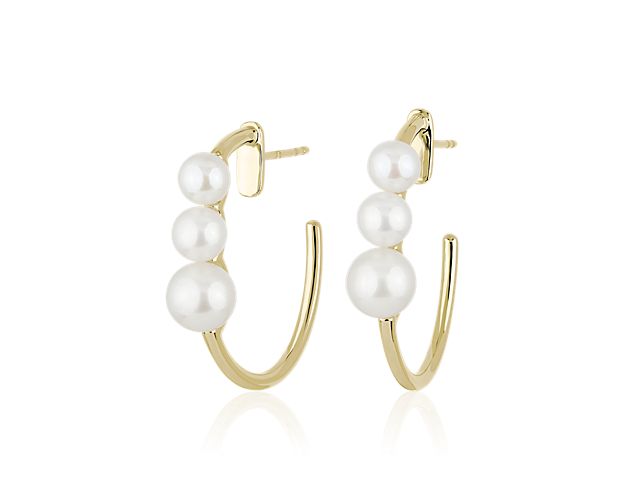 Opt for classic elegance in these warmly lustrous yellow gold hoop earrings. The front-facing edge is set with three pearls in graduating sizes, adding a sophisticated finish.