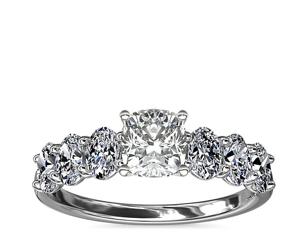 Love shines bright in this beautiful platinum and diamond engagement ring. Beset with a row of sparkling oval diamonds this design will showcase your choice of center beautifully,